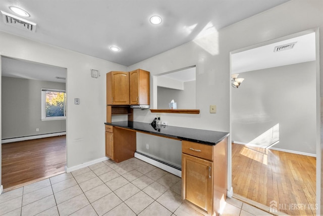 kitchen with a baseboard heating unit, dark countertops, baseboard heating, light wood-style floors, and recessed lighting