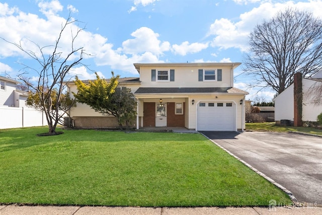 traditional-style house featuring asphalt driveway, an attached garage, and covered porch