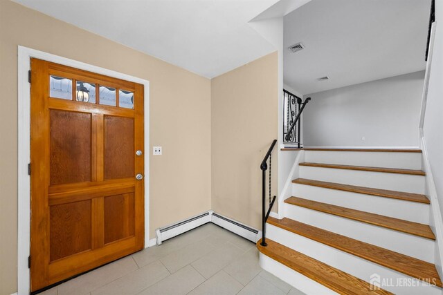 tiled entrance foyer with stairs and a baseboard radiator