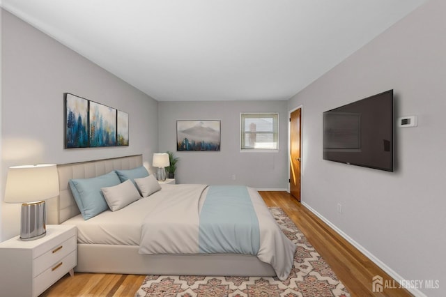 bedroom with light wood finished floors and baseboards