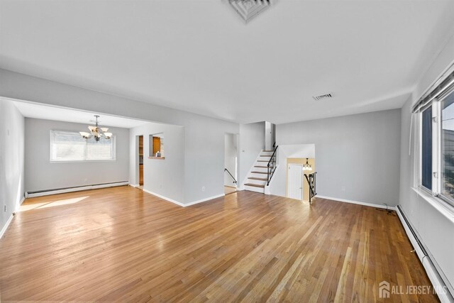 unfurnished living room with a baseboard radiator, a chandelier, light wood-type flooring, and baseboards