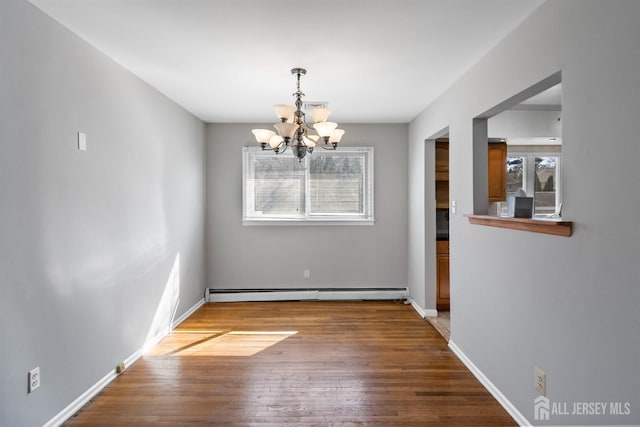 unfurnished dining area featuring a chandelier, a baseboard radiator, wood-type flooring, and baseboards