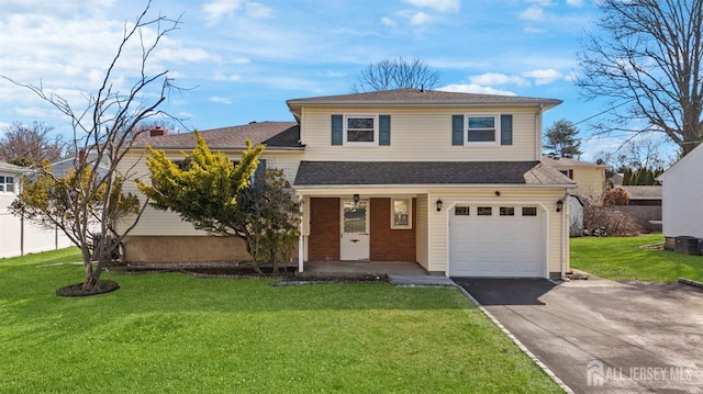 tri-level home featuring driveway, a front yard, an attached garage, and a porch