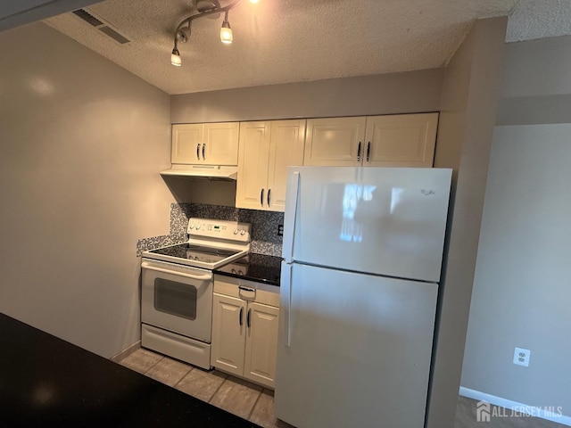 kitchen with dark countertops, visible vents, decorative backsplash, white cabinets, and white appliances