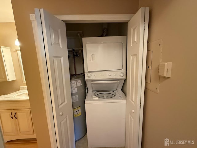 clothes washing area featuring a sink, laundry area, and stacked washer / dryer