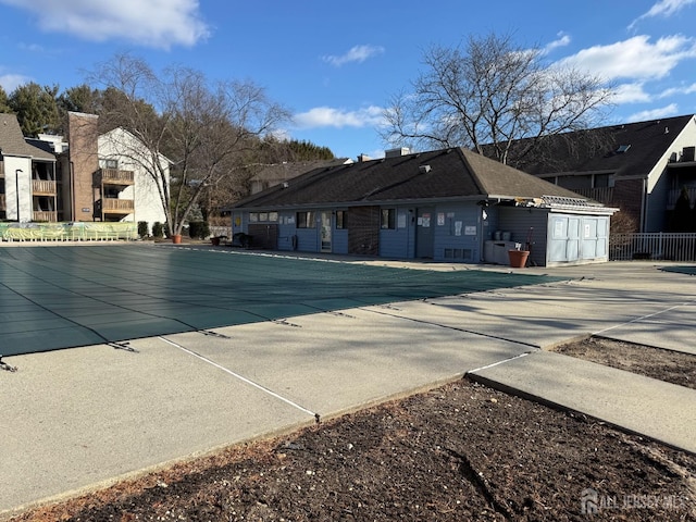 community pool featuring a residential view and fence