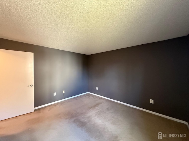 empty room featuring carpet floors, baseboards, and a textured ceiling