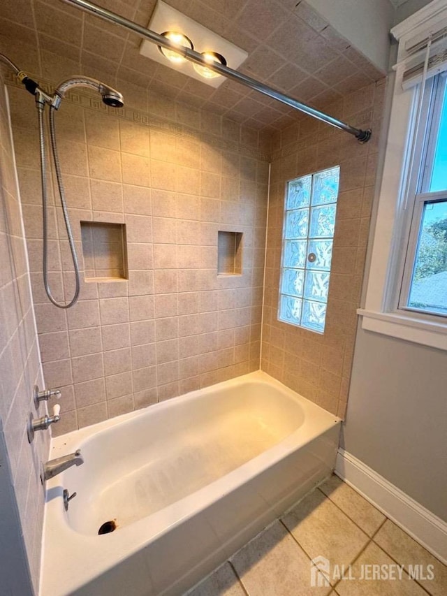 bathroom featuring tile patterned flooring and tiled shower / bath