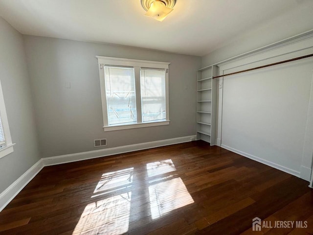 unfurnished bedroom with dark wood-type flooring