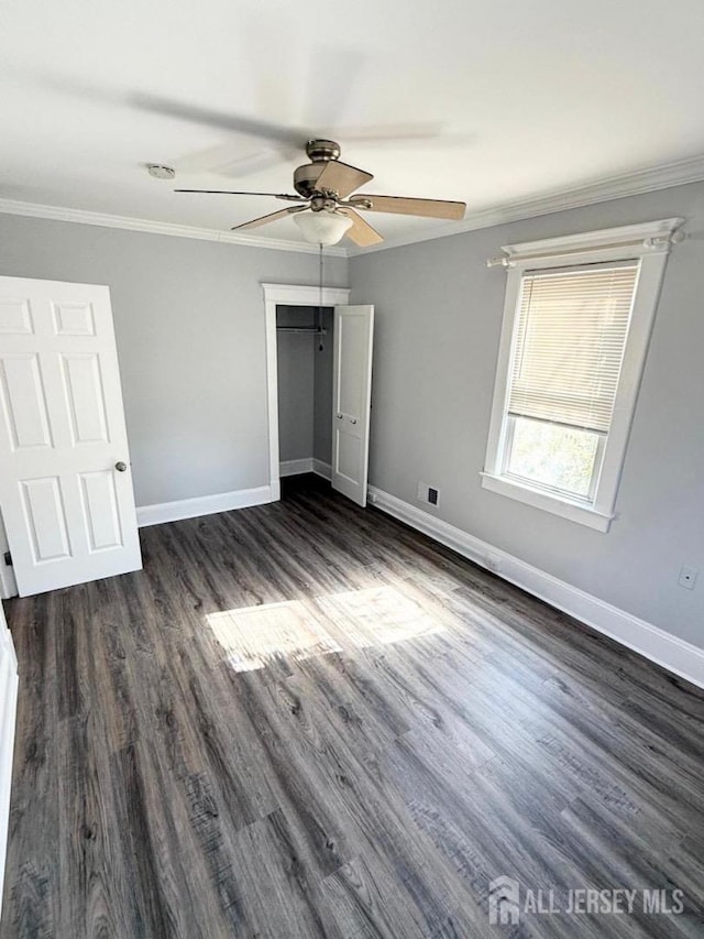 unfurnished bedroom with ceiling fan, dark hardwood / wood-style floors, and ornamental molding