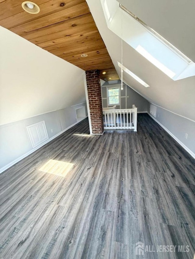 additional living space with lofted ceiling with skylight, dark wood-type flooring, and wood ceiling