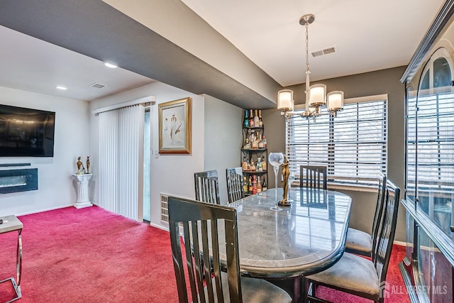 carpeted dining space with an inviting chandelier