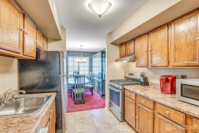 kitchen featuring light tile patterned flooring, sink, a chandelier, hanging light fixtures, and stainless steel appliances