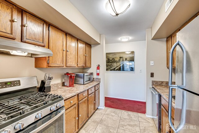 kitchen with appliances with stainless steel finishes and light tile patterned floors