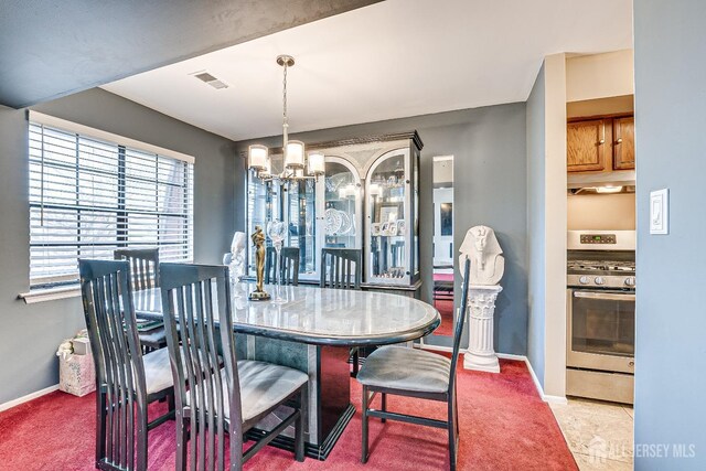 carpeted dining space with a chandelier