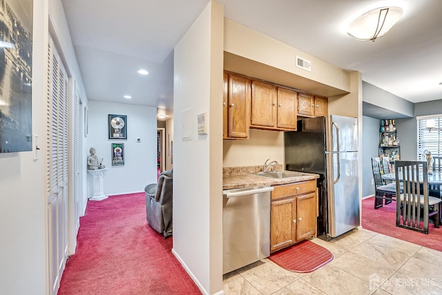 kitchen with stainless steel appliances, sink, and light carpet