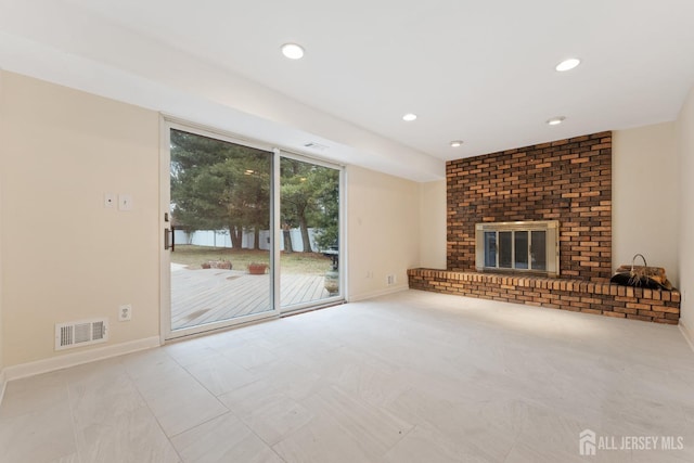 unfurnished living room featuring a fireplace, visible vents, and baseboards