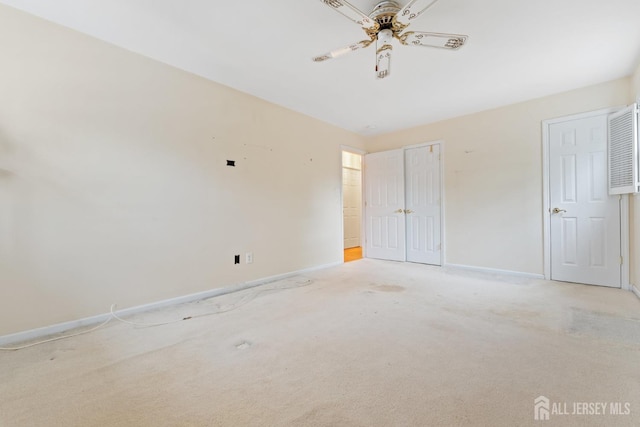 unfurnished bedroom featuring baseboards, light colored carpet, and a ceiling fan