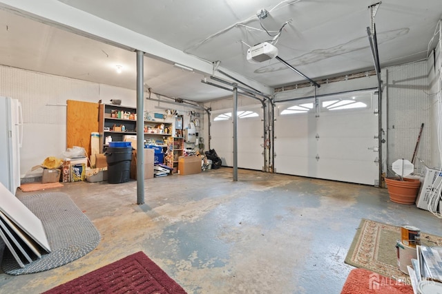 garage with freestanding refrigerator and a garage door opener