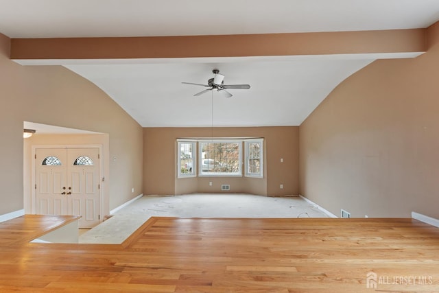 unfurnished living room featuring baseboards, a ceiling fan, and lofted ceiling with beams