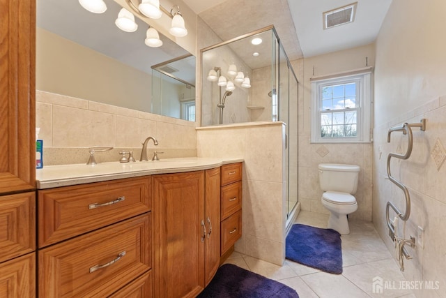 full bath featuring a stall shower, vanity, tile walls, visible vents, and toilet