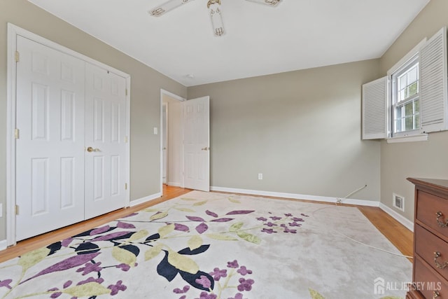 bedroom featuring light wood-style flooring, baseboards, visible vents, and a closet