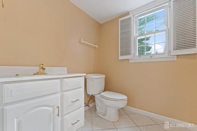 bathroom with vanity, toilet, baseboards, and tile patterned floors