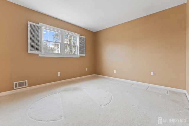 unfurnished room with baseboards, visible vents, and light carpet