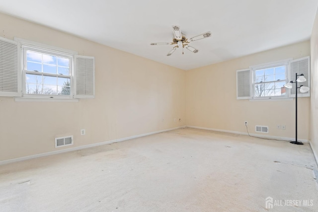 unfurnished room featuring baseboards, visible vents, and light carpet