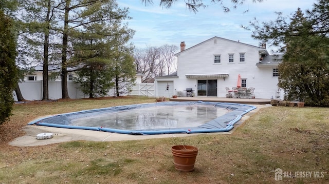 view of swimming pool featuring fence, a wooden deck, a fenced in pool, and a yard