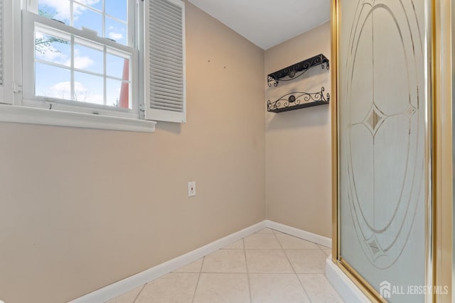 spare room with baseboards and light tile patterned floors