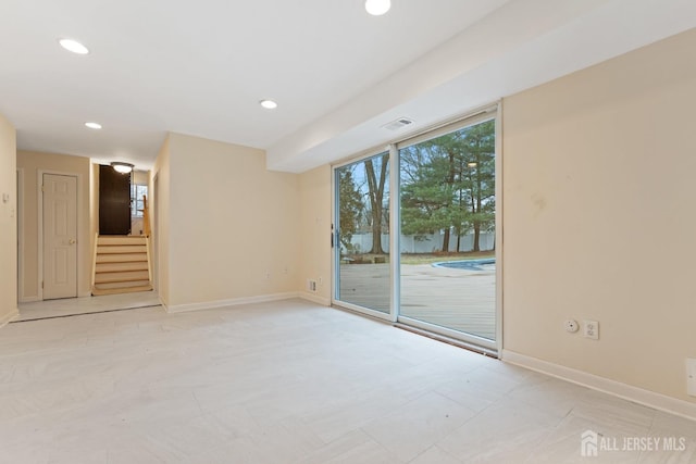 empty room with baseboards, visible vents, recessed lighting, and stairs