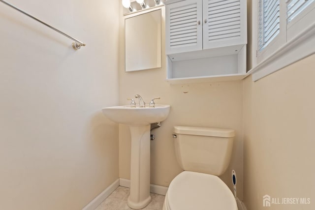 bathroom featuring baseboards, toilet, and tile patterned flooring