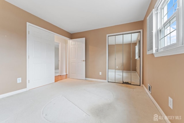 unfurnished bedroom featuring baseboards, visible vents, and carpet flooring