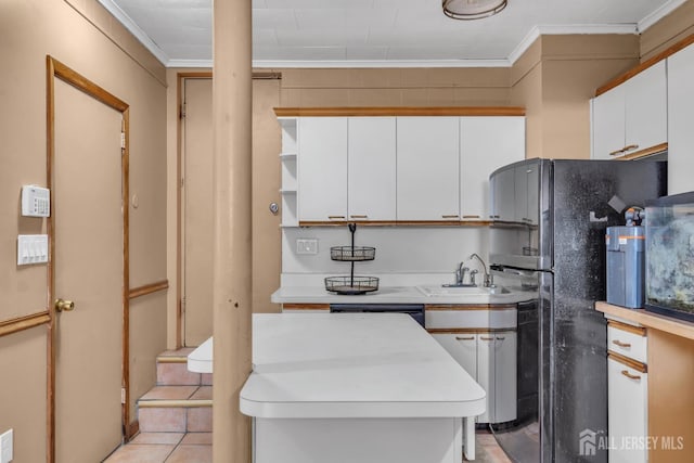 kitchen with crown molding, white cabinetry, a sink, and light countertops