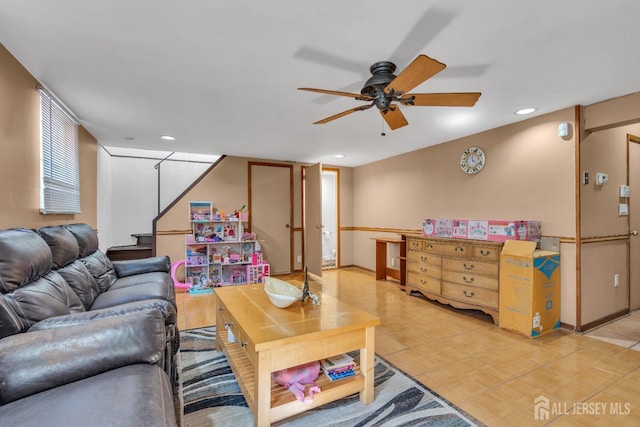 living room featuring recessed lighting, baseboards, ceiling fan, and stairway