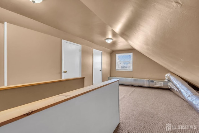 additional living space with carpet flooring, lofted ceiling, and visible vents