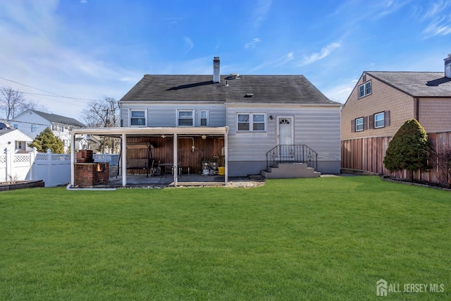rear view of house with a yard, a patio, and a fenced backyard