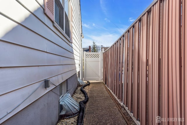 view of side of property with fence and a gate