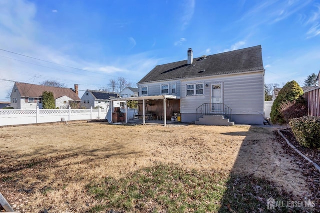 back of property featuring a chimney, a fenced backyard, and roof with shingles