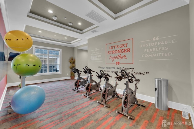 workout room with crown molding and a tray ceiling