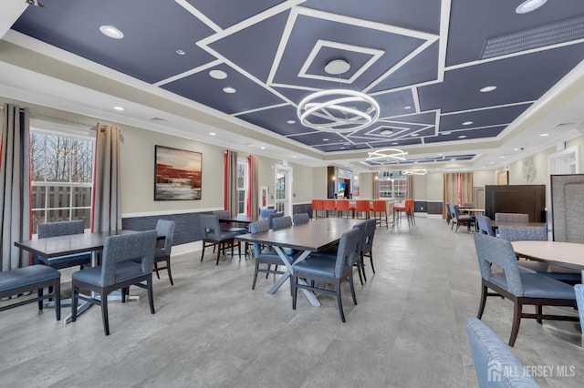 dining room with a raised ceiling and a chandelier