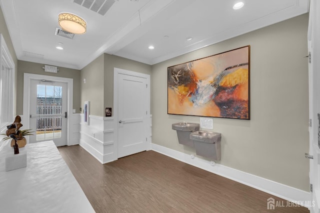 foyer with dark wood-type flooring and ornamental molding