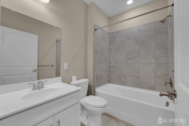 full bathroom featuring vanity, tile patterned floors, toilet, and tiled shower / bath