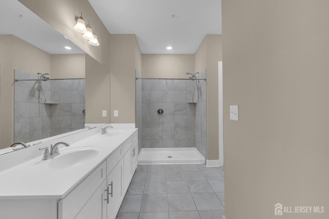 bathroom featuring vanity, tile patterned flooring, and a tile shower