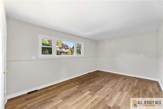 empty room with hardwood / wood-style flooring