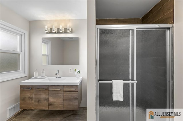 bathroom with tile patterned floors, vanity, and a shower with door