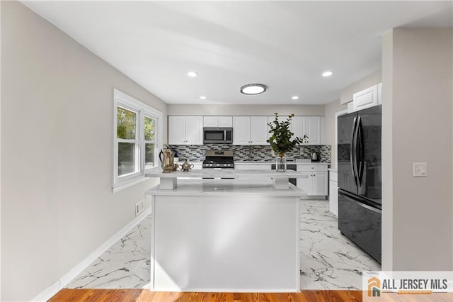 kitchen featuring backsplash, white cabinets, and appliances with stainless steel finishes