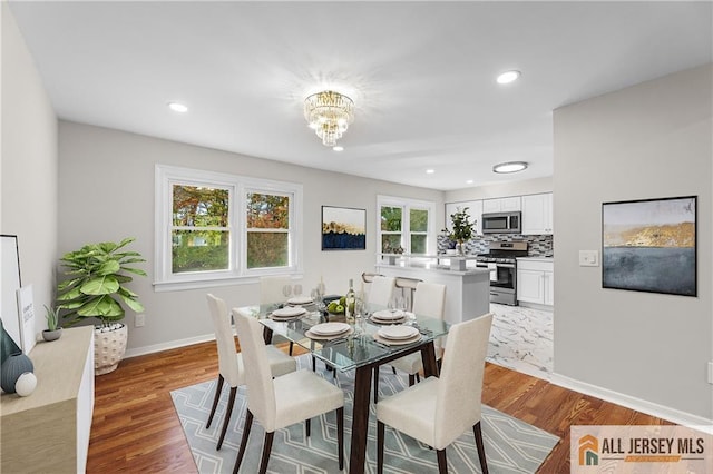 dining area with an inviting chandelier and light hardwood / wood-style flooring