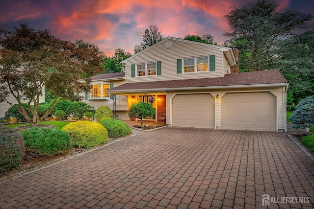 64 Annette Dr, Edison, NJ 08820 - split level home with decorative driveway, a chimney, and an attached garage